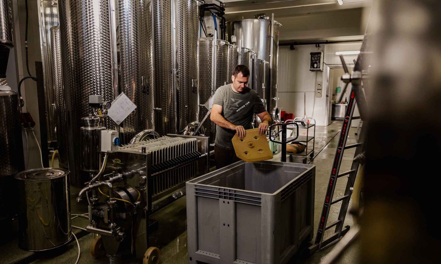 Winzer bei der Weinverarbeitung im Weinkeller des Weinguts Pilch – moderne Edelstahltanks, sorgfältige Handarbeit und traditionelle Weinherstellung in der Südsteiermark.