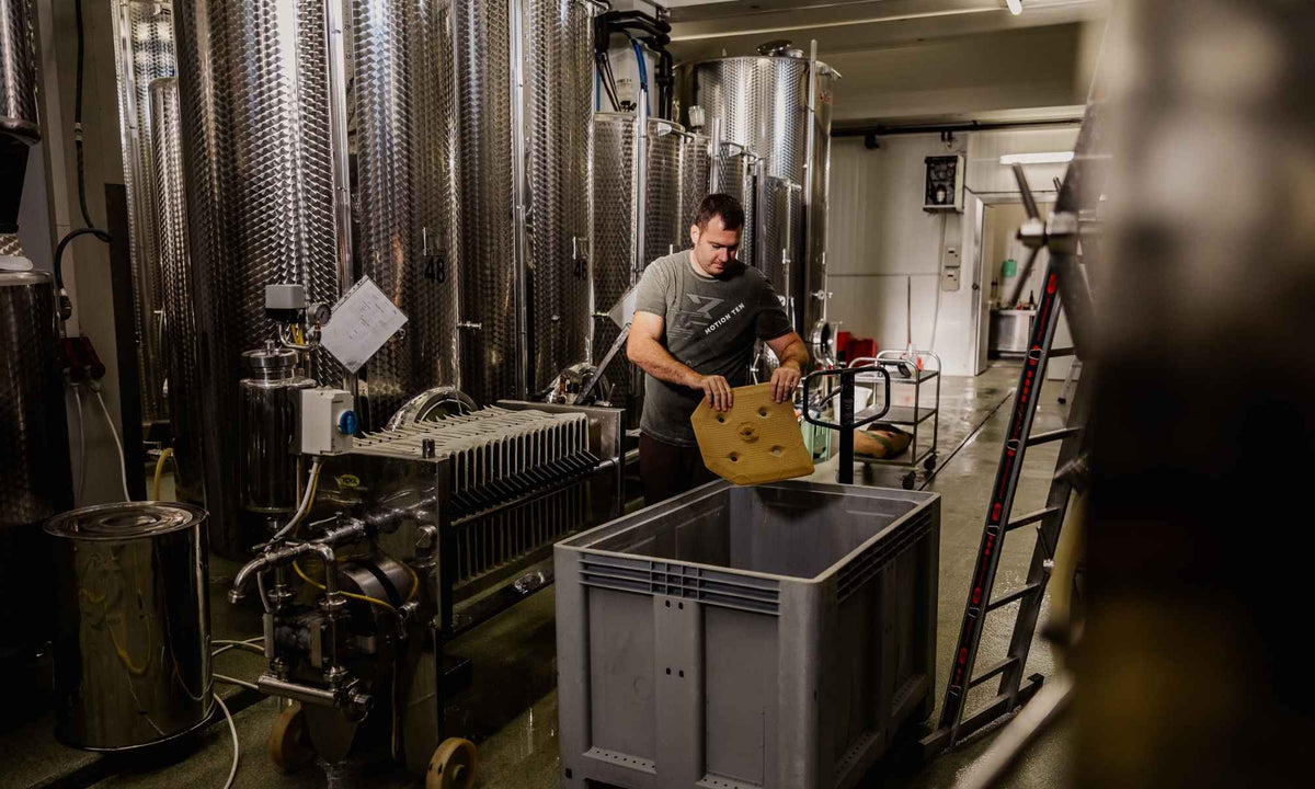 Winzer bei der Weinverarbeitung im Weinkeller des Weinguts Pilch – moderne Edelstahltanks, sorgfältige Handarbeit und traditionelle Weinherstellung in der Südsteiermark.